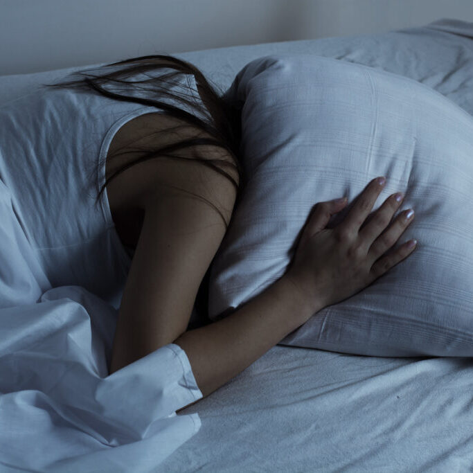 Girl covered her head with a pillow.Insomnia